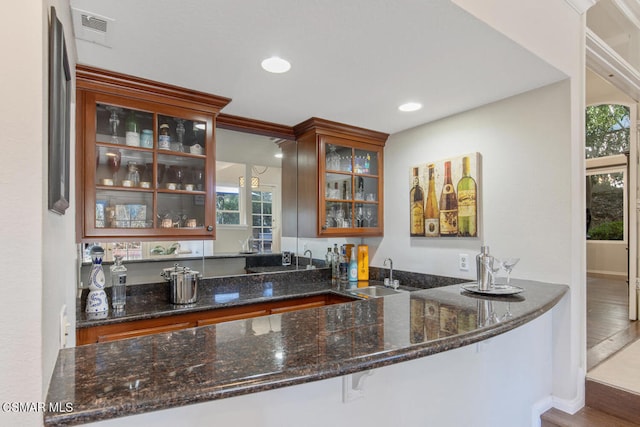 bar featuring sink and dark stone countertops