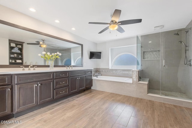 bathroom with vanity, wood-type flooring, and plus walk in shower