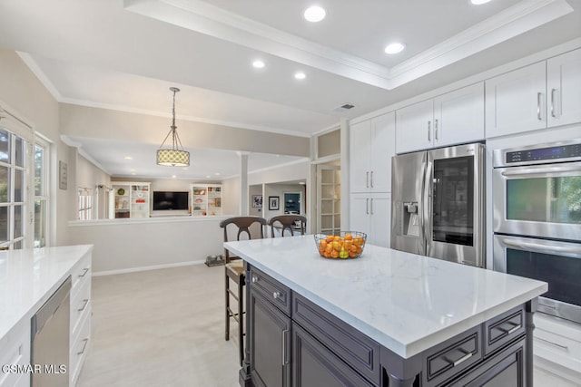 kitchen featuring white cabinetry, stainless steel appliances, hanging light fixtures, and light stone counters