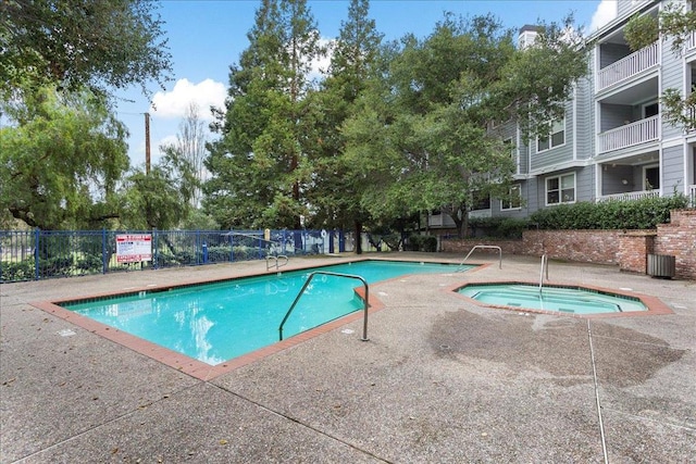 view of swimming pool with a community hot tub and central air condition unit