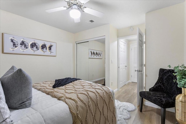 bedroom with light hardwood / wood-style floors, a closet, and ceiling fan