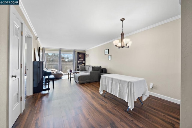 dining space featuring crown molding, dark hardwood / wood-style flooring, and a chandelier