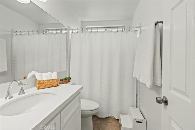 bathroom with vanity, tile patterned floors, toilet, and walk in shower