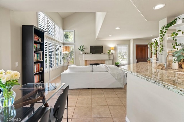 tiled living room featuring sink and a fireplace