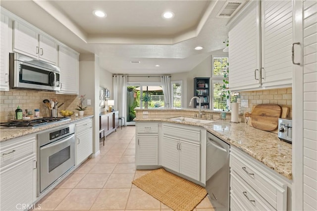 kitchen featuring white cabinetry, stainless steel appliances, sink, and decorative backsplash