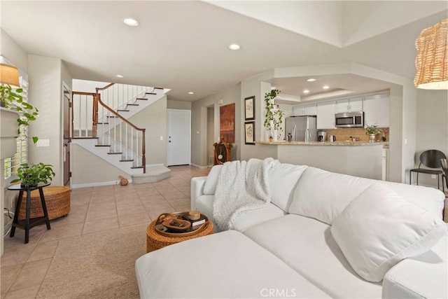 tiled living room featuring a tray ceiling