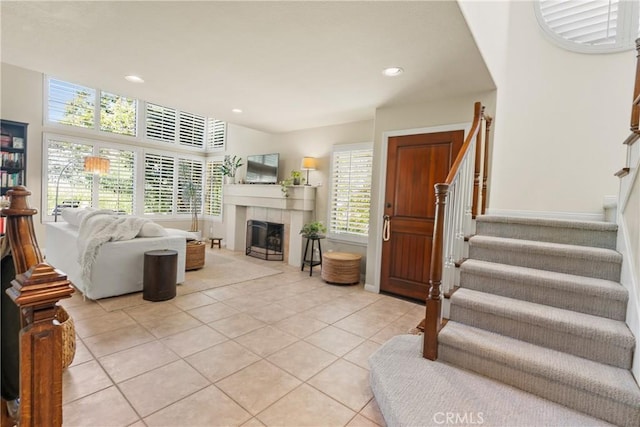 living room with a tile fireplace and light tile patterned floors