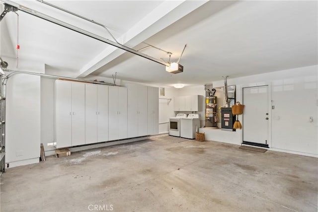 garage with a garage door opener, washing machine and dryer, and water heater