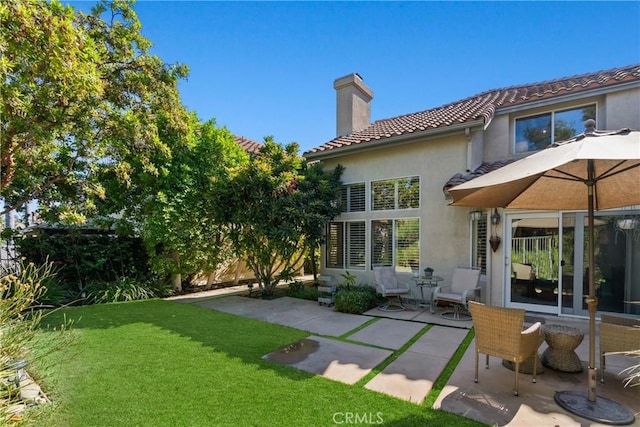 back of property featuring a patio and a lawn