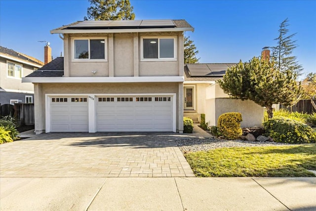 view of front of home featuring a garage and solar panels