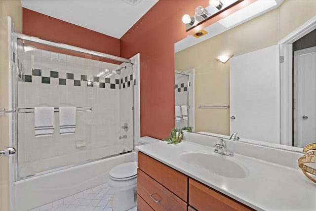 full bathroom featuring shower / bath combination with glass door, a skylight, vanity, tile patterned floors, and toilet