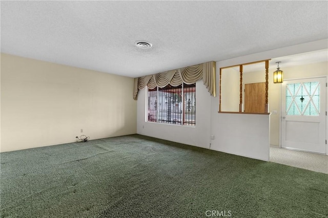 carpeted empty room with a textured ceiling