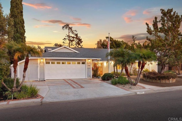 single story home featuring a garage, driveway, and a shingled roof