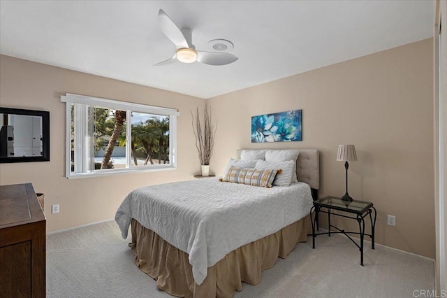 bedroom featuring baseboards, light carpet, and ceiling fan