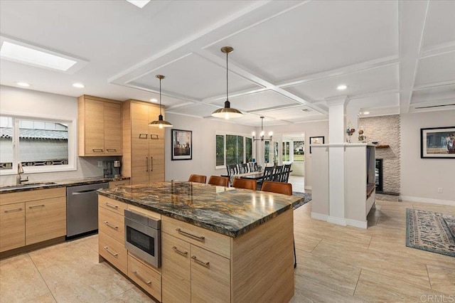 kitchen with light brown cabinets, coffered ceiling, a sink, stainless steel appliances, and pendant lighting