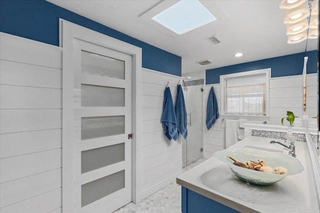 bathroom featuring vanity, a shower stall, and visible vents