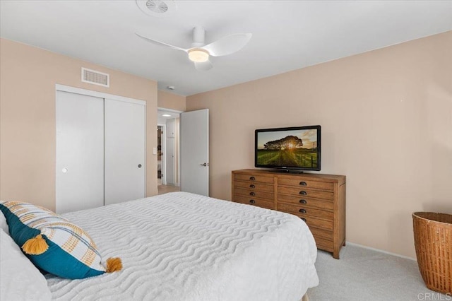 bedroom featuring a ceiling fan, baseboards, visible vents, a closet, and light carpet