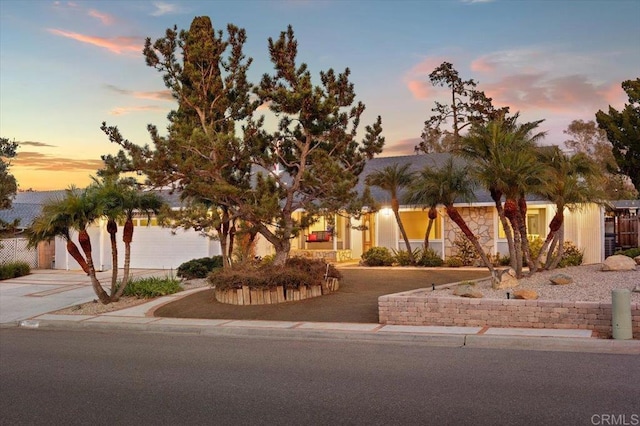 view of front facade with a garage, stone siding, and driveway