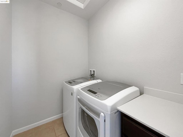 laundry room with light tile patterned floors and washing machine and clothes dryer