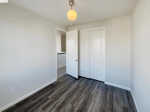 unfurnished bedroom featuring dark hardwood / wood-style flooring and a closet