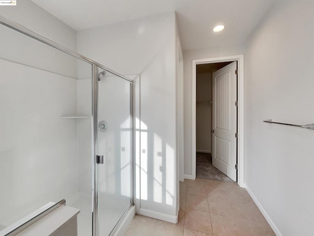 bathroom featuring a shower with door and tile patterned flooring