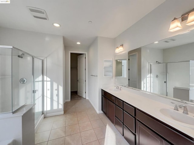 bathroom featuring vanity, a shower with shower door, and tile patterned floors