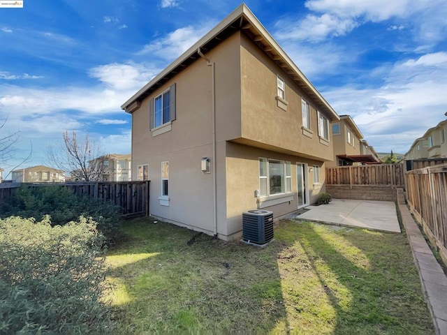 rear view of property featuring central AC, a lawn, and a patio area