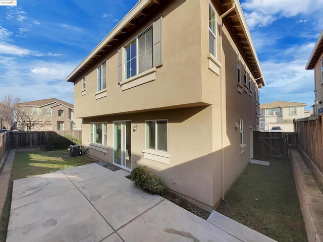 back of property featuring a patio, central AC unit, and a lawn