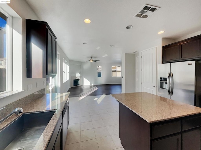 kitchen with sink, a center island, light tile patterned floors, ceiling fan, and stainless steel appliances