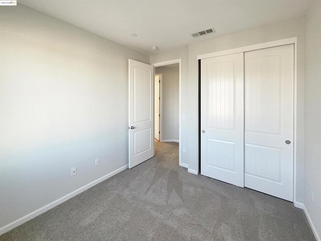 unfurnished bedroom featuring carpet floors and a closet