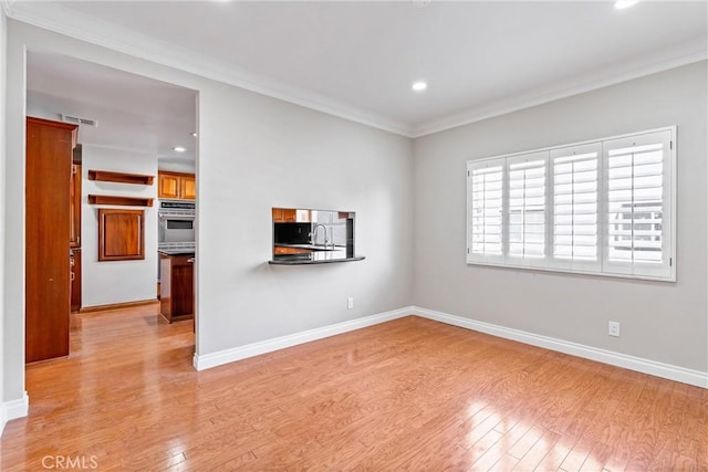 unfurnished living room featuring light wood finished floors, recessed lighting, visible vents, ornamental molding, and baseboards