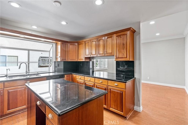 kitchen with light wood finished floors, brown cabinets, and a sink