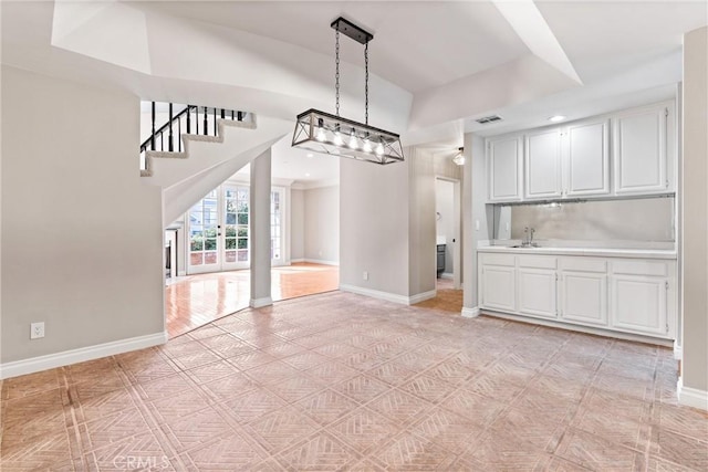 unfurnished dining area featuring recessed lighting, a sink, visible vents, baseboards, and french doors