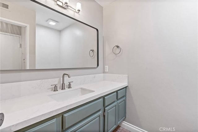 bathroom with vanity, visible vents, and baseboards