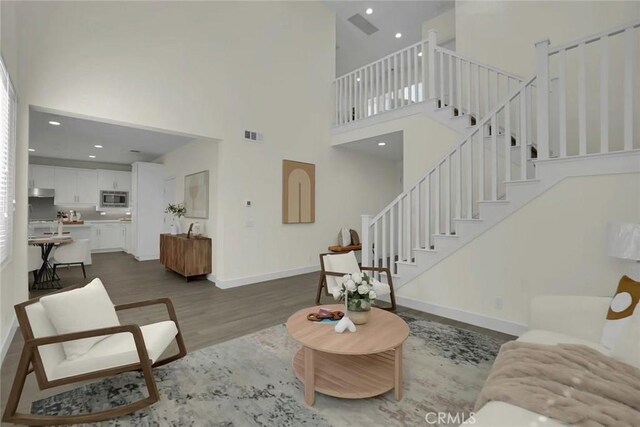 living room featuring a high ceiling and dark wood-type flooring