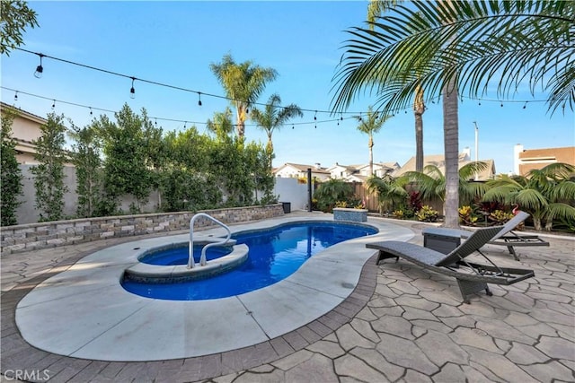 view of swimming pool featuring an in ground hot tub and a patio