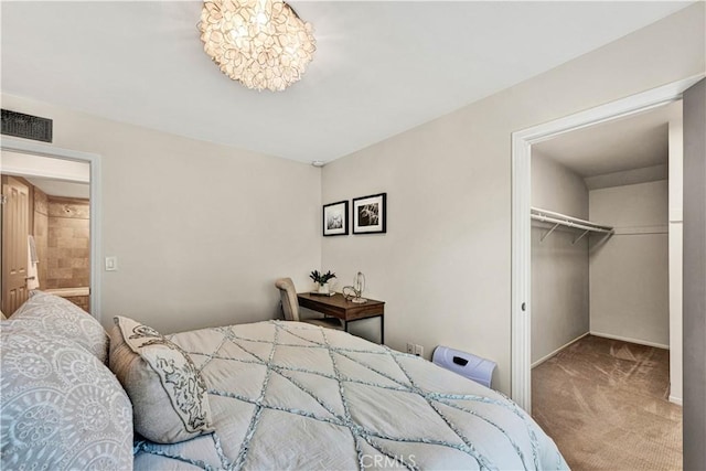 bedroom featuring an inviting chandelier, a walk in closet, carpet floors, and a closet