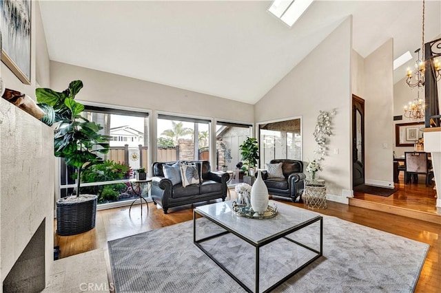 living room featuring hardwood / wood-style flooring, high vaulted ceiling, and a notable chandelier