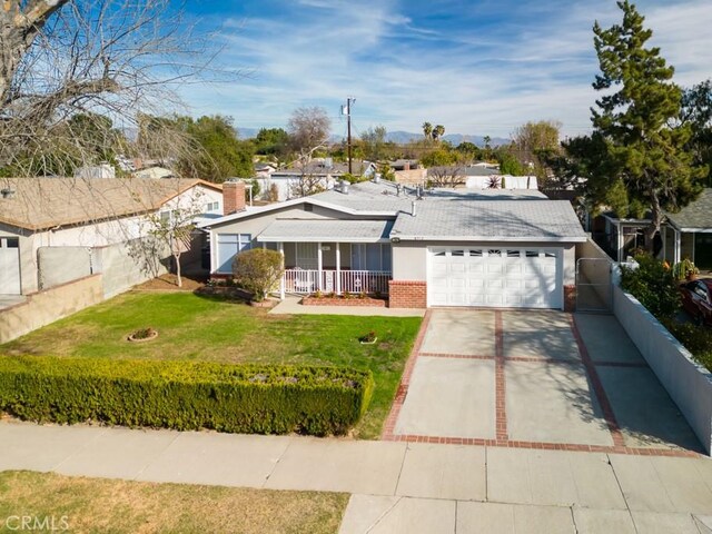 single story home featuring a porch, a garage, and a front yard