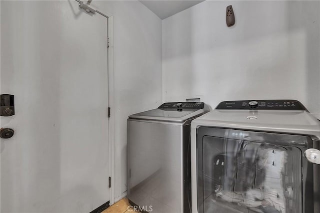 laundry room featuring washing machine and dryer and light tile patterned floors