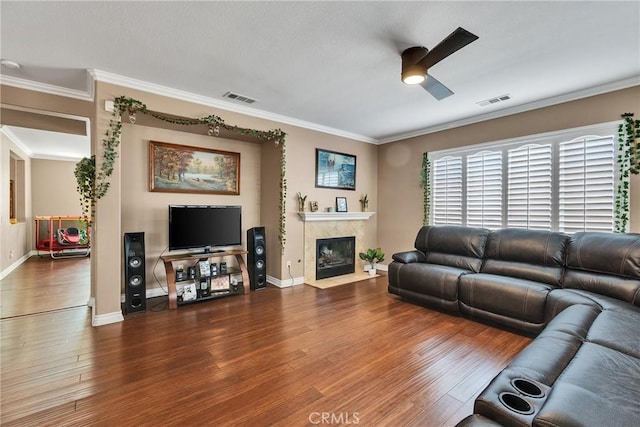 living room with crown molding, dark wood-type flooring, and ceiling fan