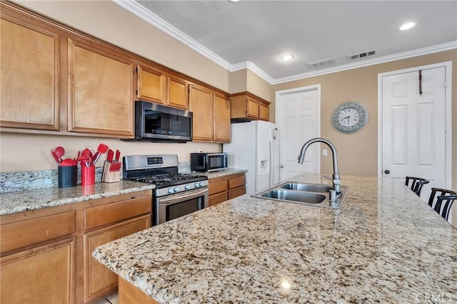 kitchen featuring sink, ornamental molding, stainless steel range with gas stovetop, an island with sink, and white refrigerator with ice dispenser