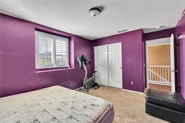 bedroom with carpet floors, a closet, and a textured ceiling