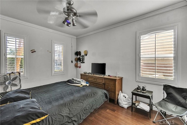 bedroom with crown molding, ceiling fan, and dark hardwood / wood-style flooring