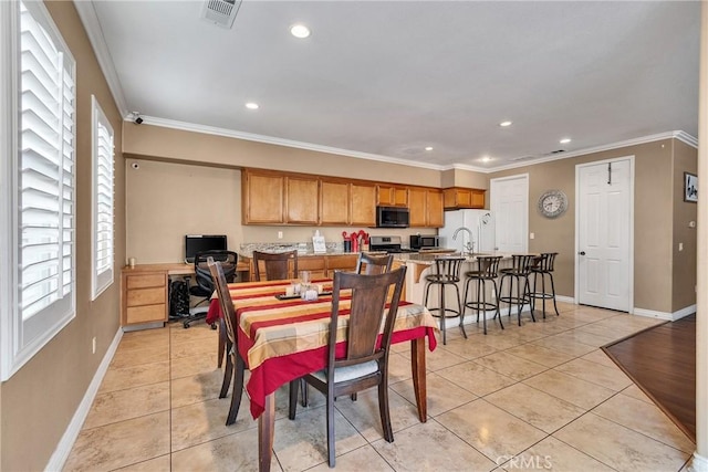 dining room featuring light tile patterned floors and ornamental molding