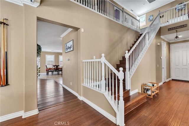 staircase with ornamental molding and wood-type flooring