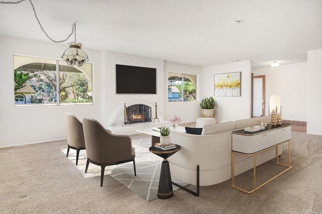 living room featuring a fireplace, carpet floors, and a textured ceiling