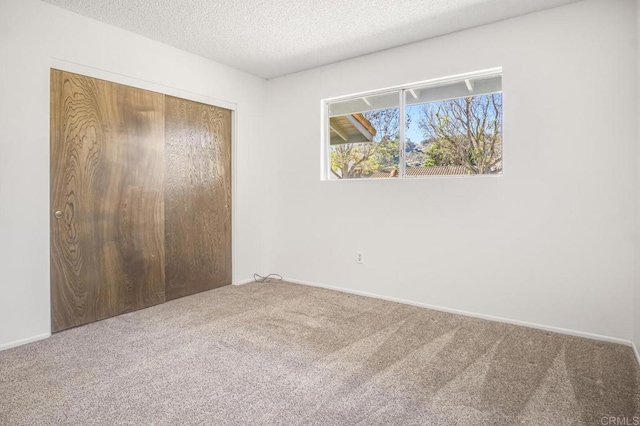 unfurnished bedroom with carpet, a textured ceiling, and a closet