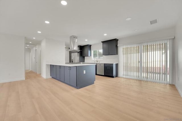 kitchen with island exhaust hood, kitchen peninsula, sink, and light wood-type flooring