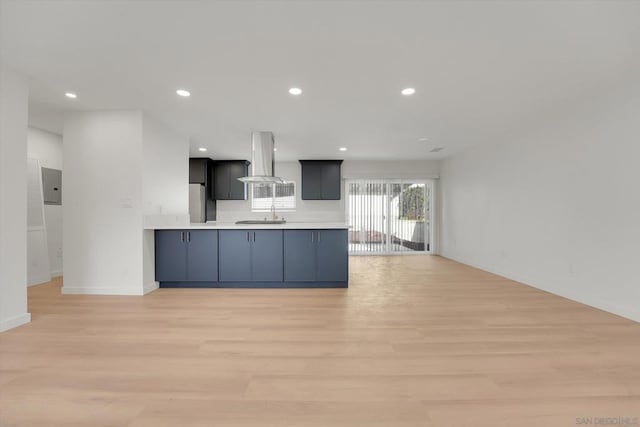 kitchen featuring island exhaust hood, refrigerator, light wood-type flooring, and kitchen peninsula